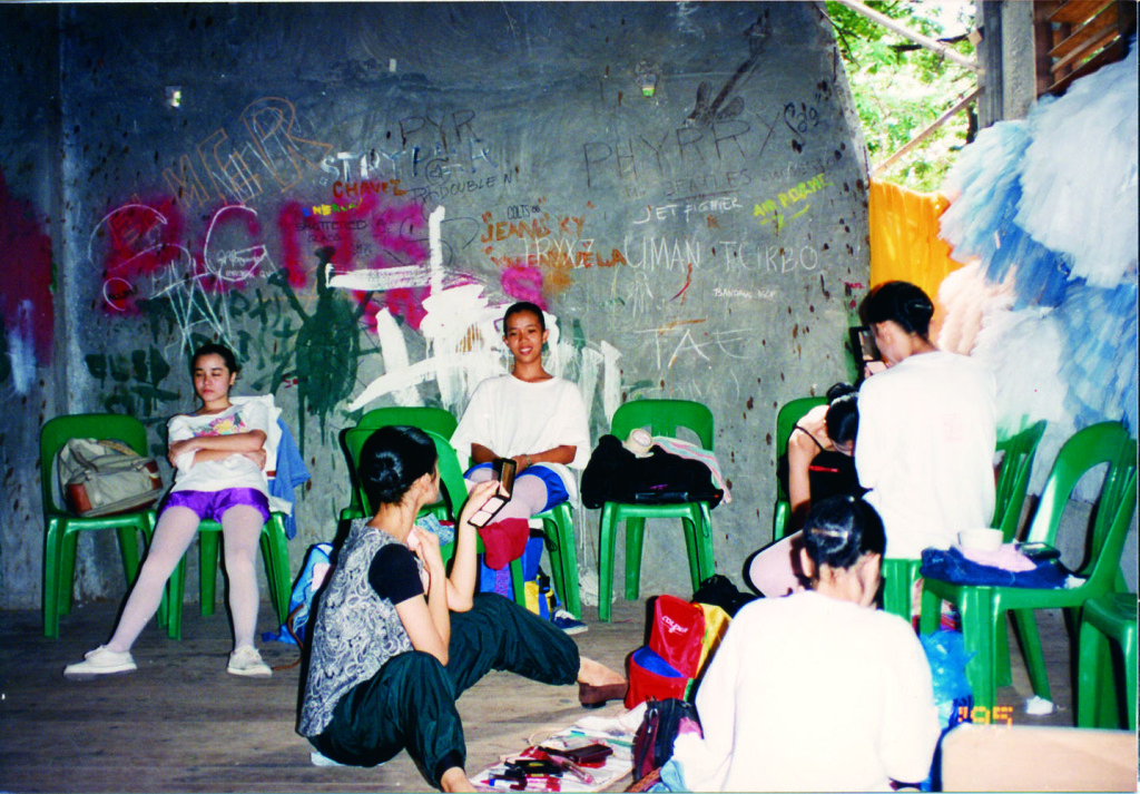 In one of their stops in Mindanao, the BM girls prepare for a show with a grafitti-filled wall as backdrop.
