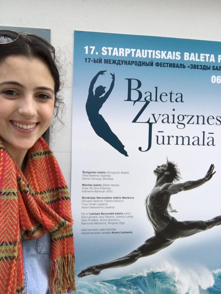 Even after losing her luggage, Katherine can't help but smile upon seeing the poster for the Jurmala gala at Dzintaru Koncertzale